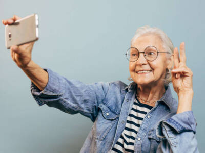 signora anziana smartphone selfie videochiamata