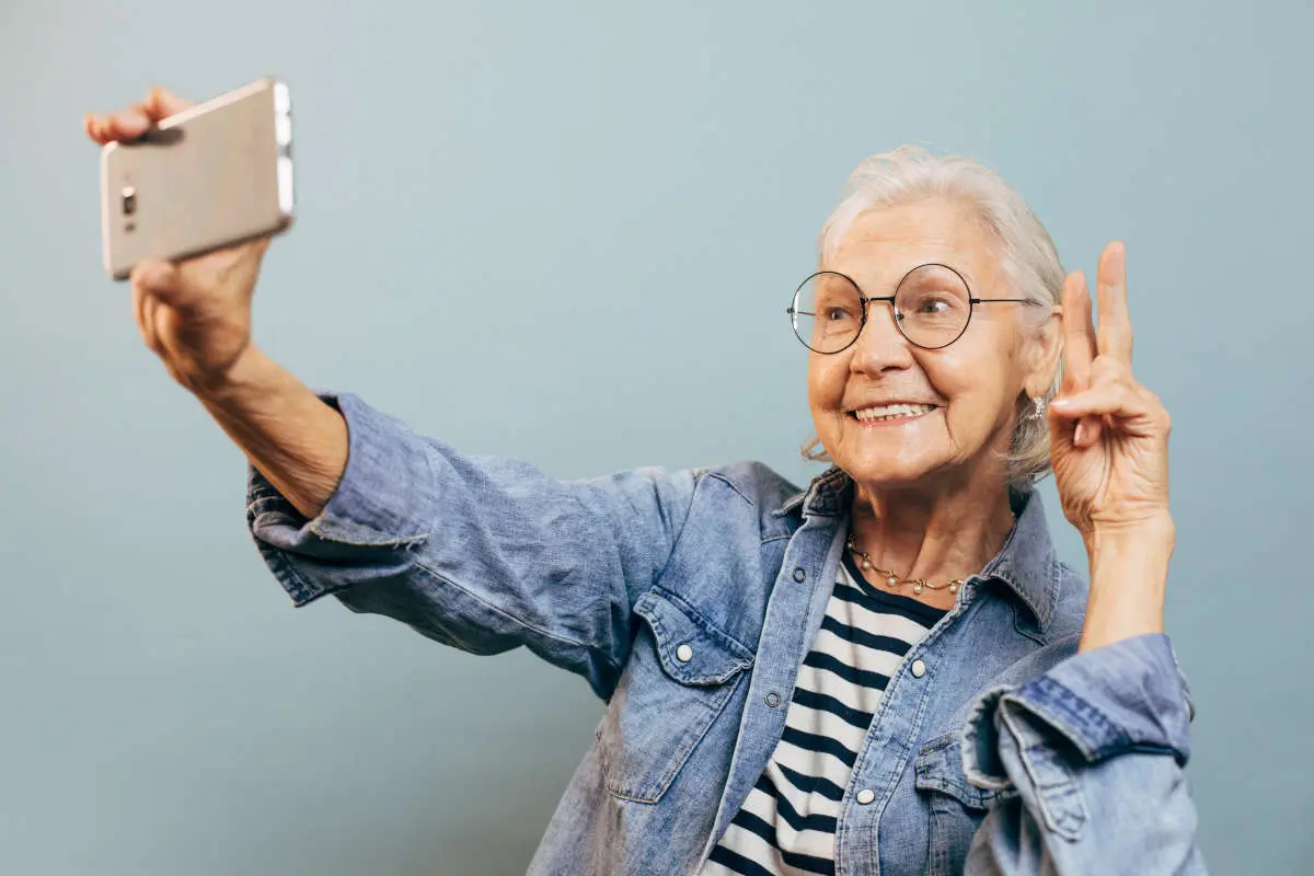 signora anziana smartphone selfie videochiamata