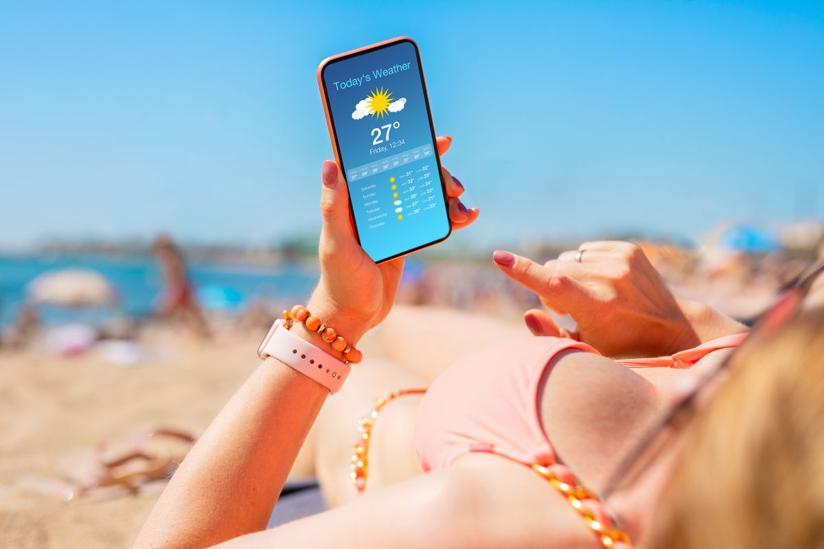 Ragazza in spiaggia con Smartphone e App meteo
