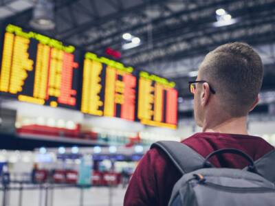 ragazzo in aeroporto controlla tabellone voli