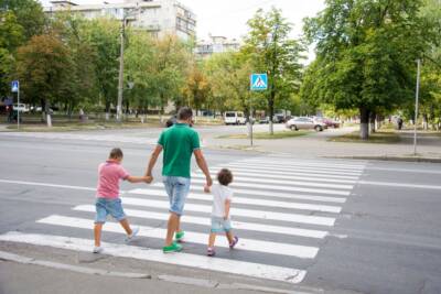 papà con figli attraversa strisce pedonali