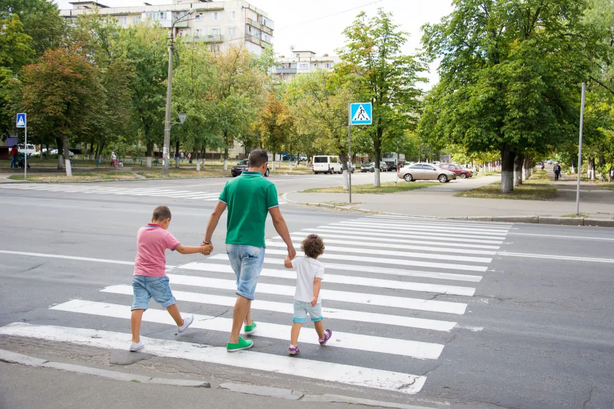 papà con figli attraversa strisce pedonali