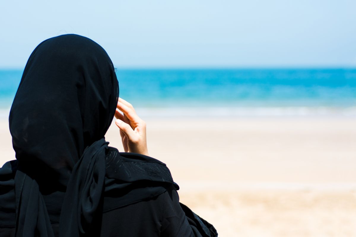 Donna musulmana con velo in spiaggia