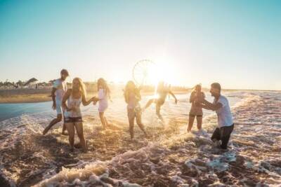 amici, festeggiano e giocano in spiaggia, mare