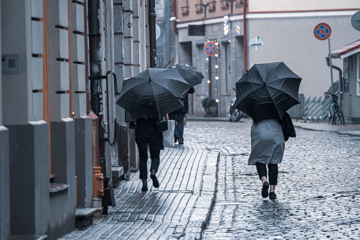 gente con ombrello cammina sotto la pioggia