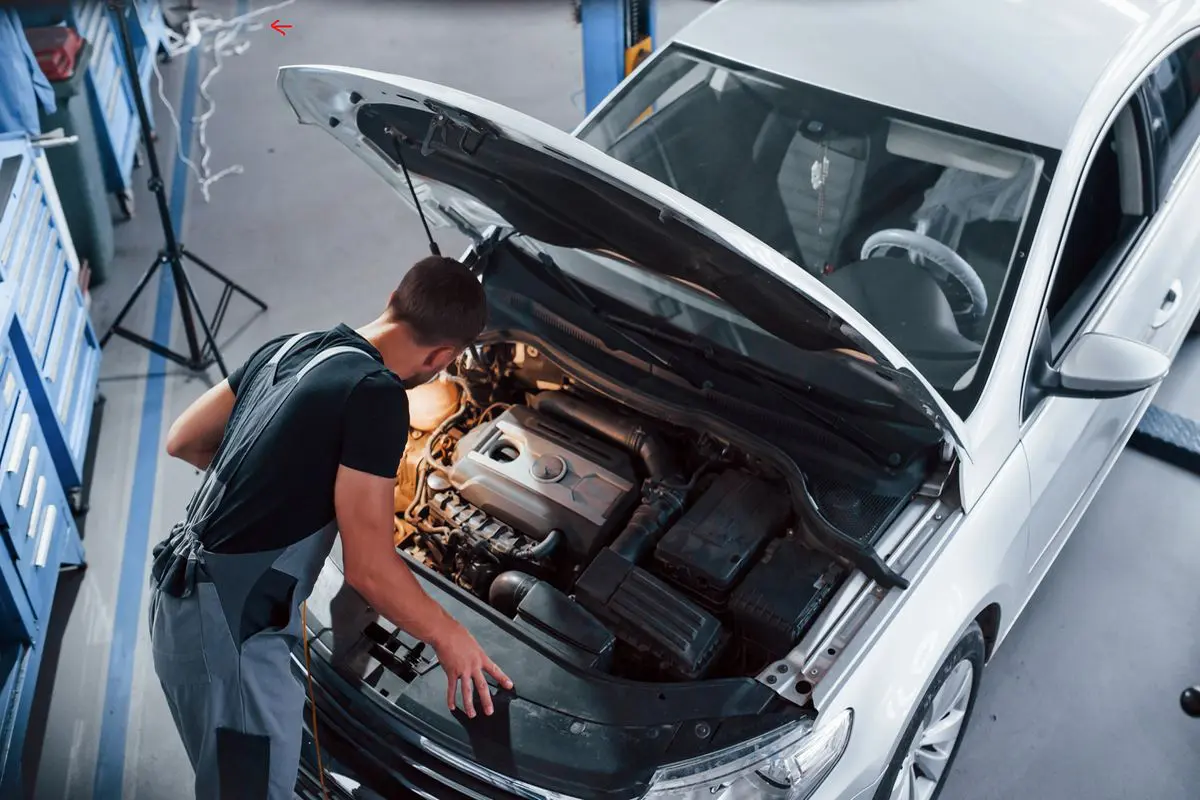 meccanico controlla motore auto, revisione