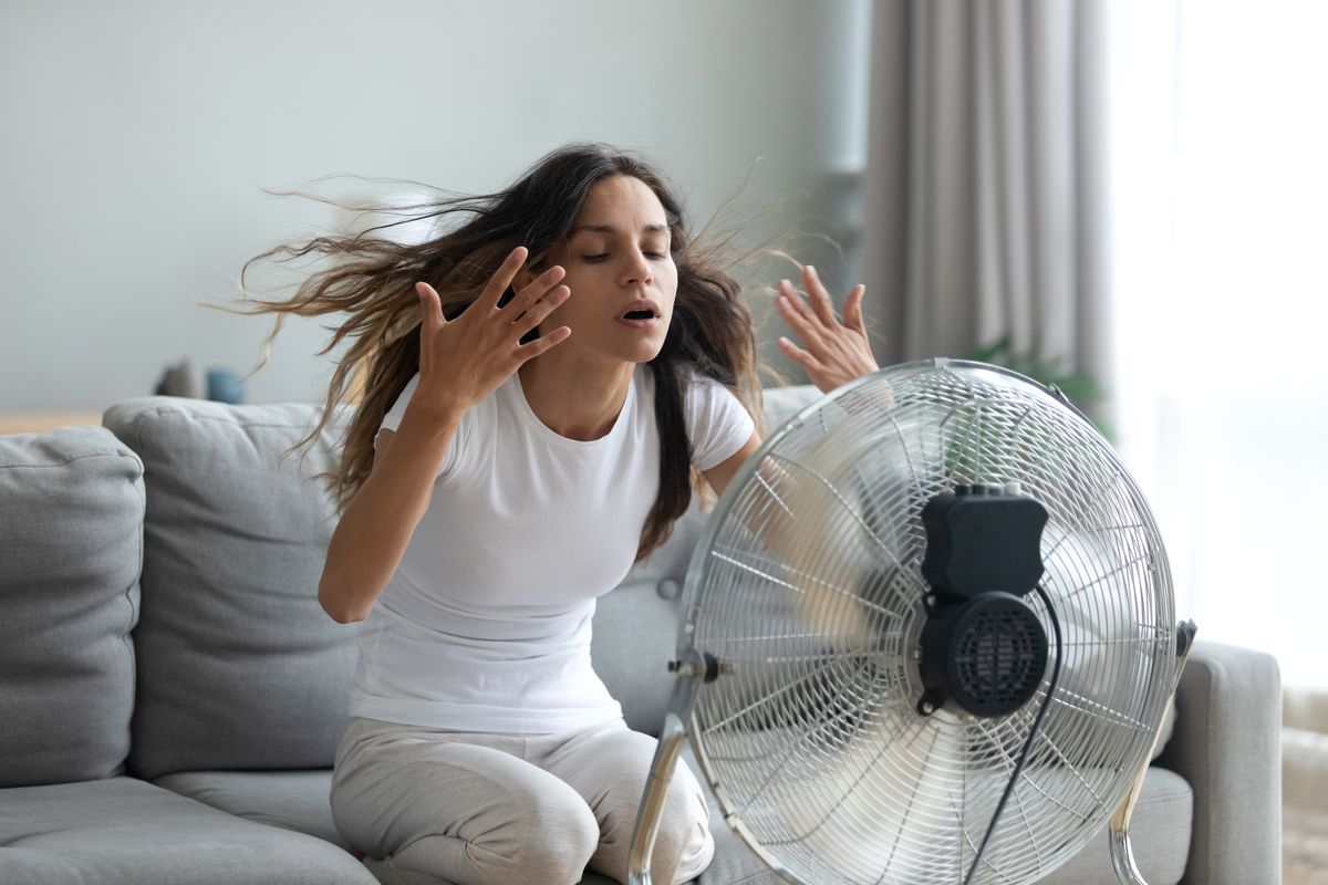 Donna usa ventilatore per il caldo