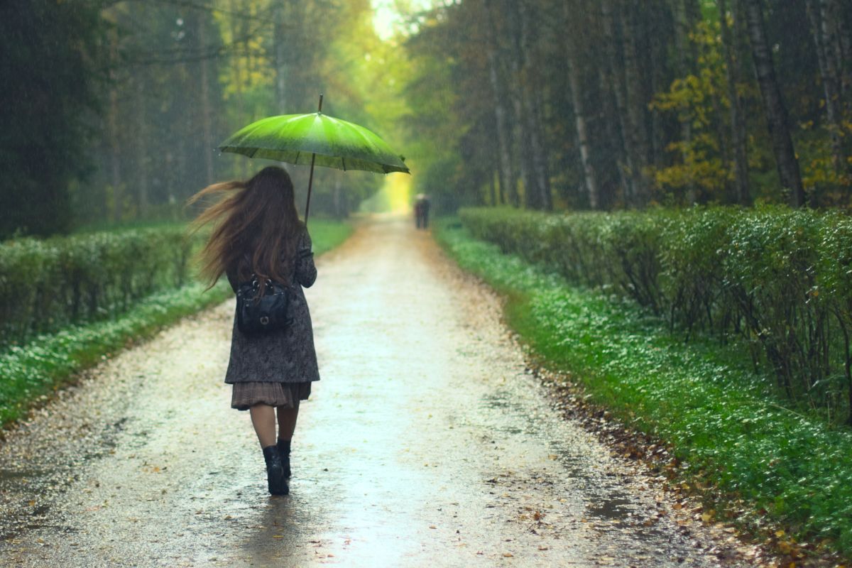 ragazza con ombrello sotto la pioggia autunnale