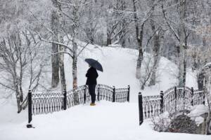 uomo cammina con ombrello sotto la neve in inverno