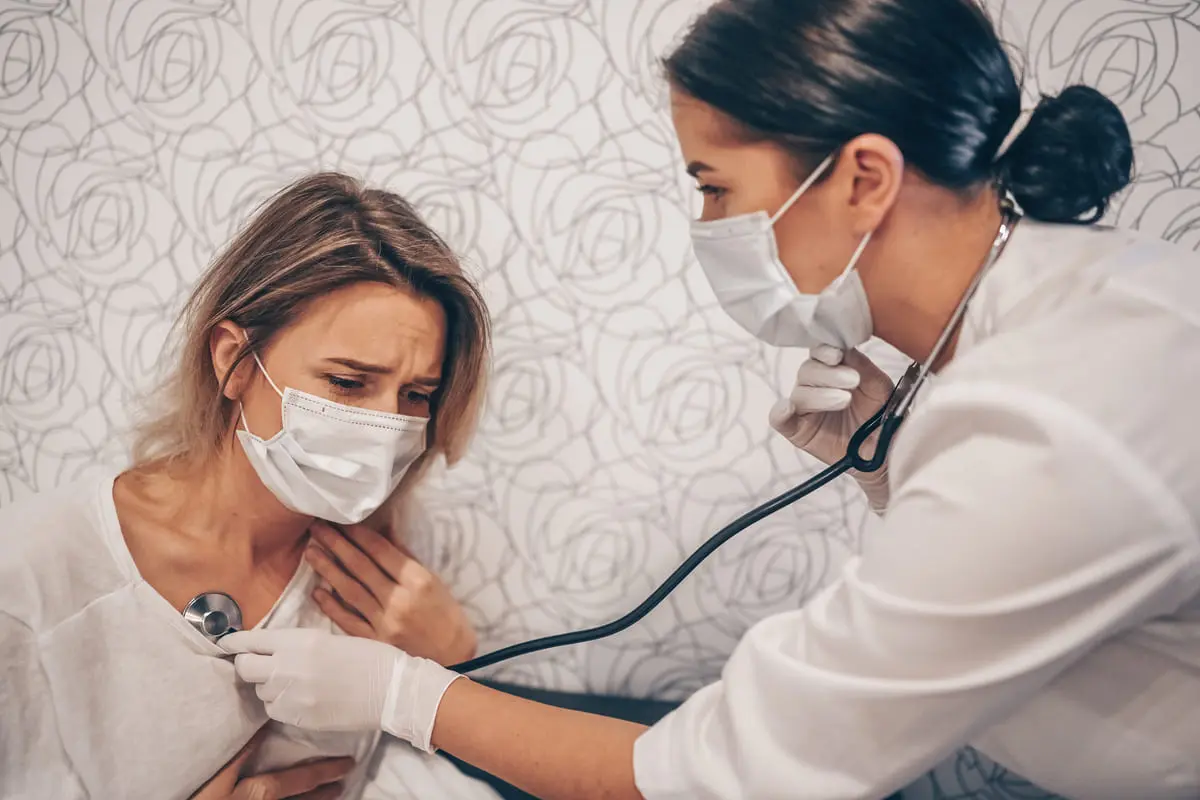 paziente con mascherina visitata da medico