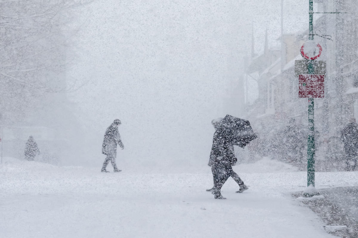 persone per strada colpite da una tempesta di neve