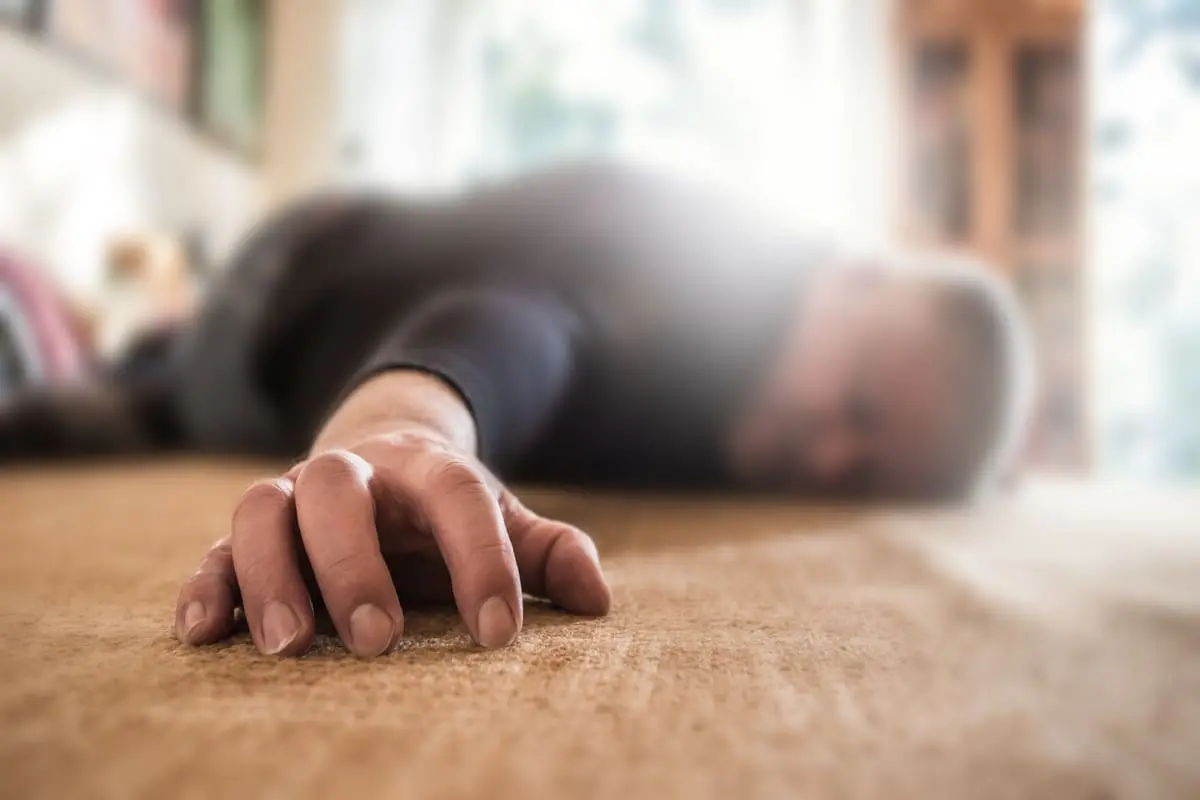 uomo morto accasciato sul pavimento