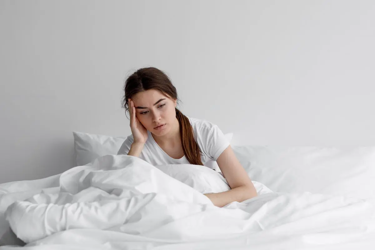 ragazza stanca seduta sul letto