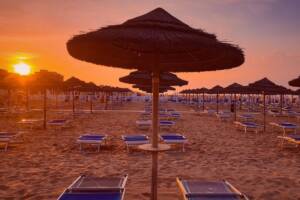 Spiaggia al tramonto ombrellone lettini