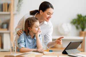 Una bambina con la mamma che fa i compiti