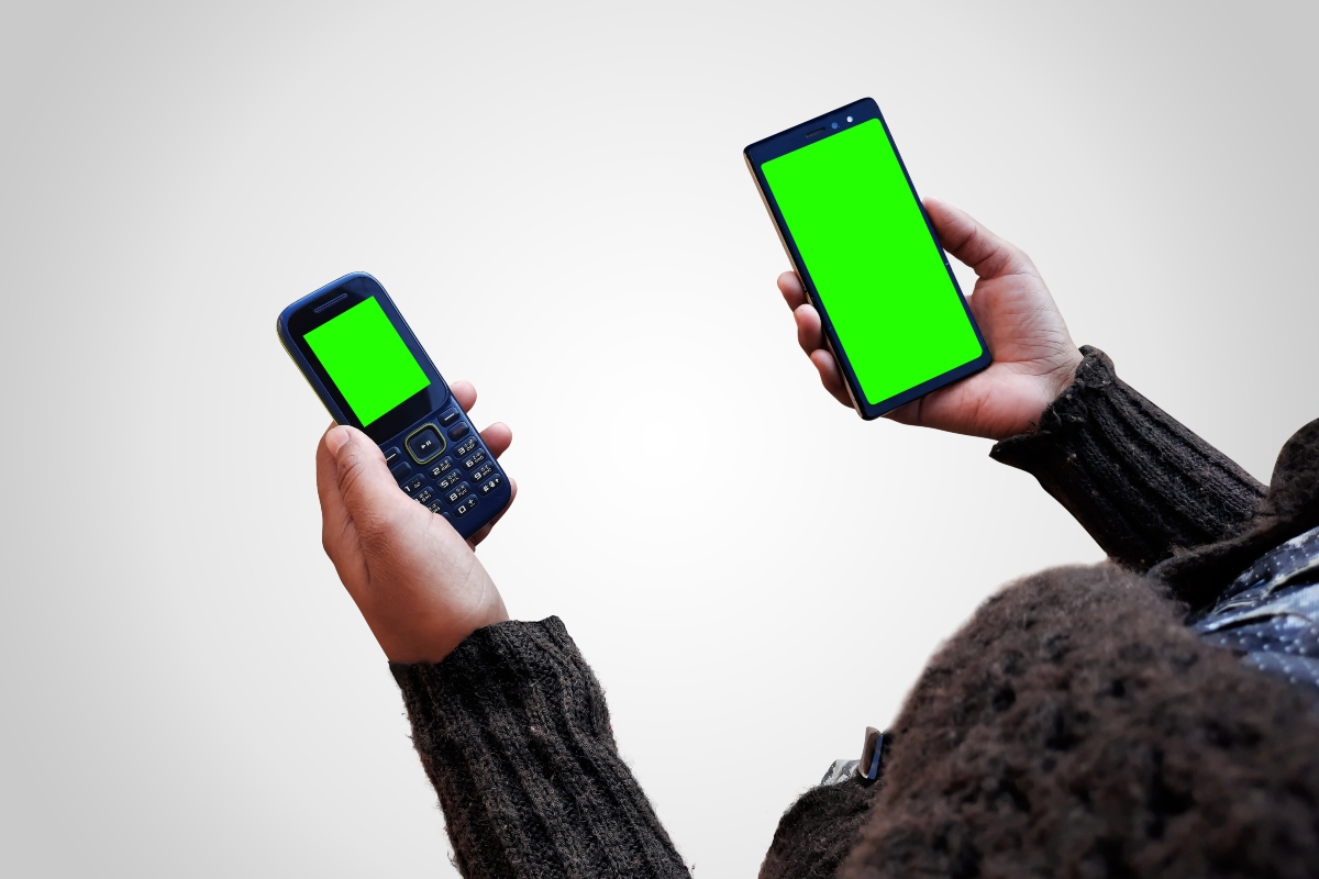 Due telefoni in mano con schermi verdi
