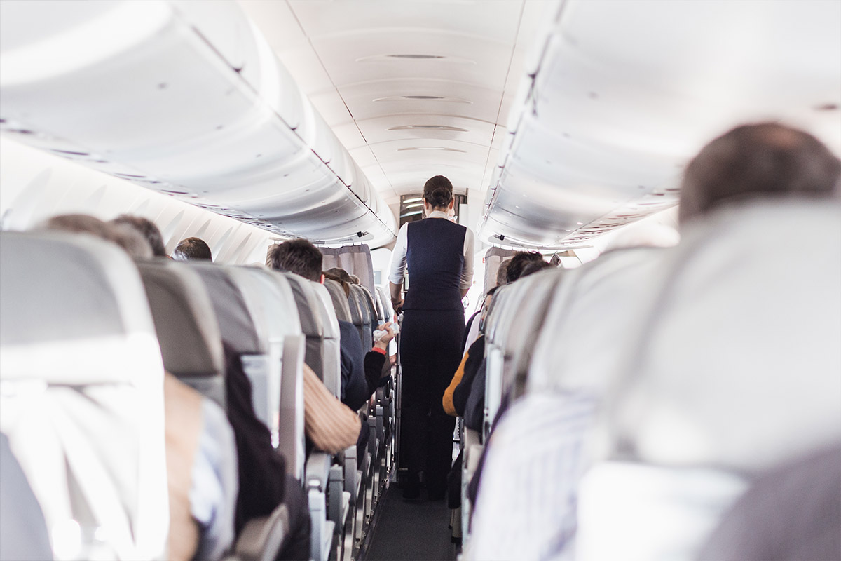 cabina di un aereo con hostess e passeggeri