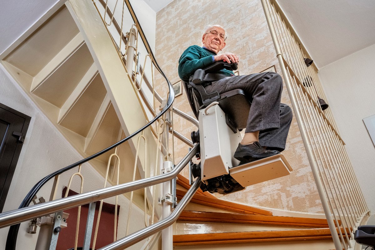 Anziano sale scale con montascale