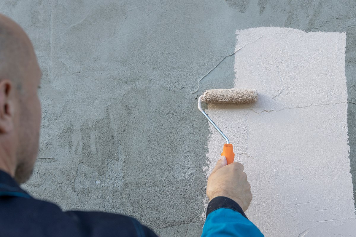 Un imbianchino dipinge un muro