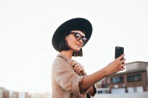 Una ragazza con un cappello e lo smarphone