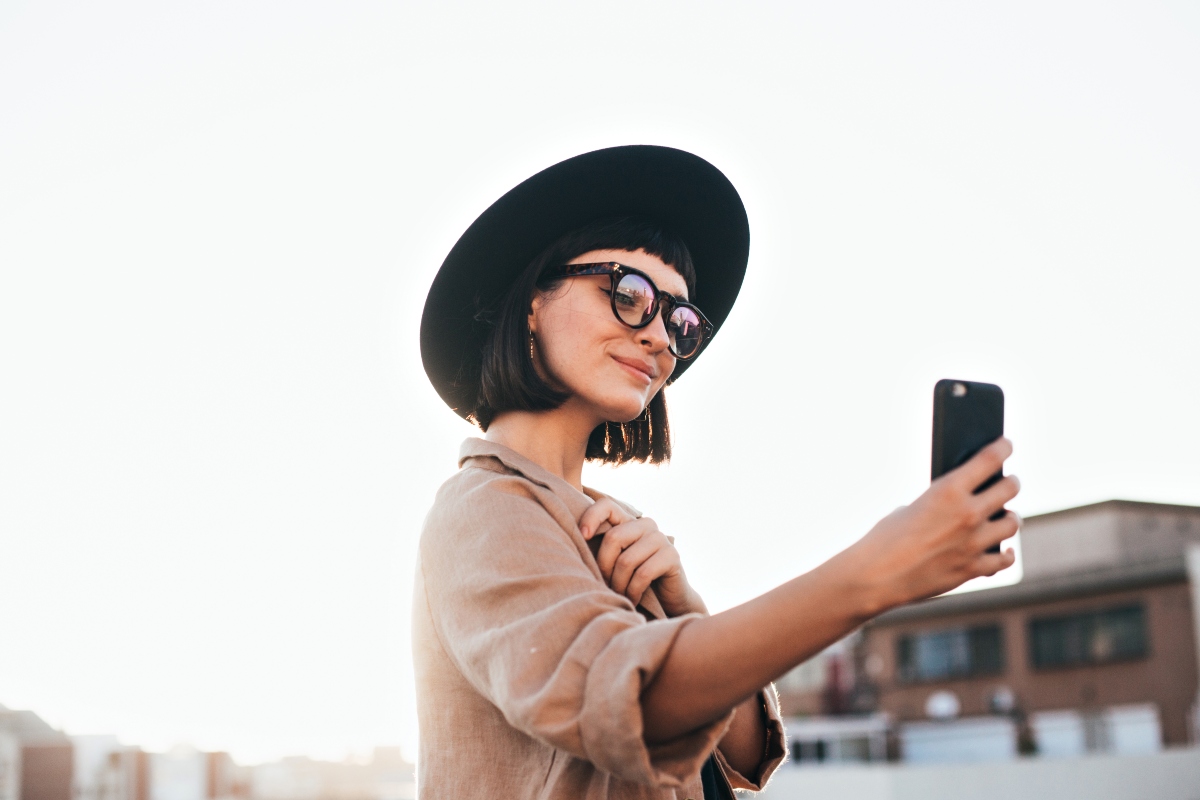 Una ragazza con un cappello e lo smarphone