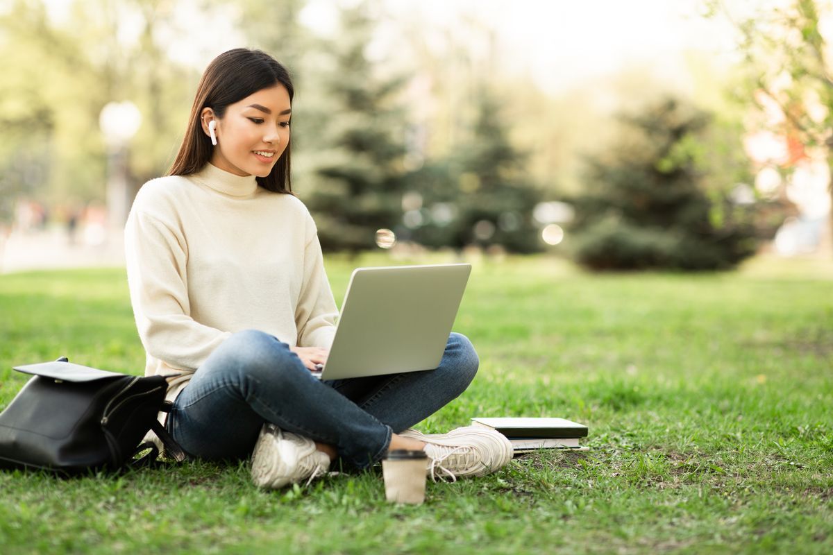 Una ragazza con gli auricolari in un parco 