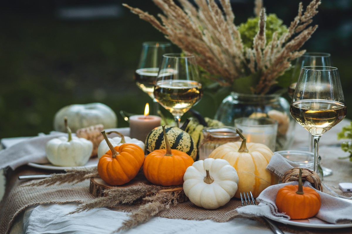 Tavola autunnale zucche calici di vino