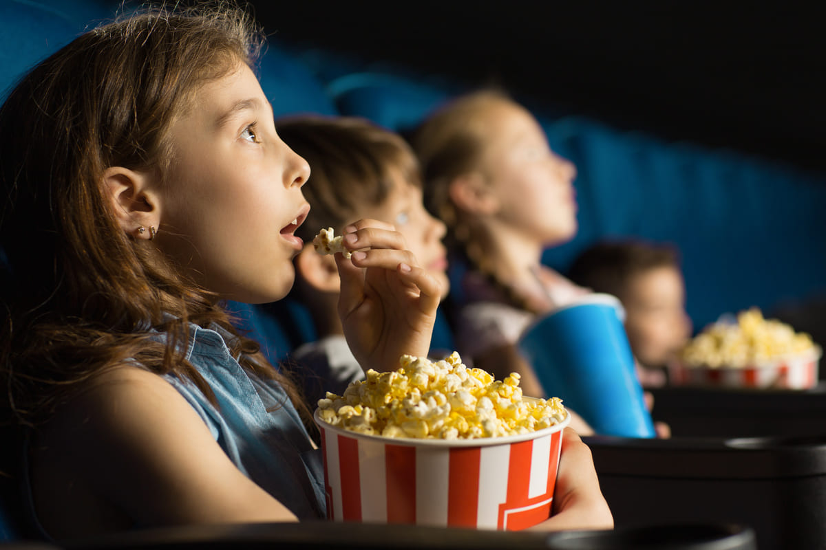 Dei bambini con i popcorn al cinema