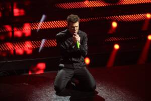 Fedez canta in ginocchio sul palco di Sanremo 2025 durante la seconda serata