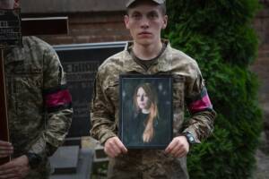 Un soldato della guardia d'onore tiene in mano il ritratto di Victoria Amelina.
