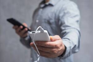 Un uomo con un cellulare e un powebank in mano