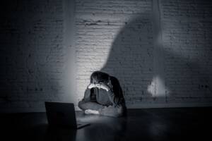 Donna spaventata seduta per terra davanti al pc