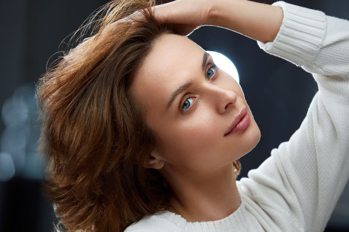 Donna castana con mano tra i capelli