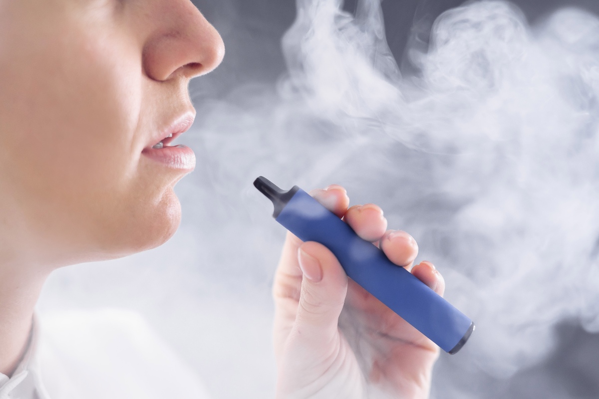 Una persona produce del fumo mentre utilizza una sigaretta elettronica.