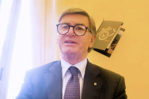 Francesco Arcieri in abito elegante blu con sfondo giallo