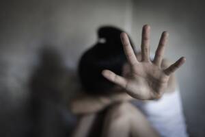 Una donna vittima di violenza con la mano davanti alla faccia