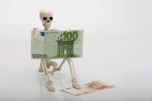 Scheletro seduto con contanti da 100 e 50 euro