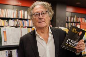 Enzo Iacchetti in posa con il suo libro in mano