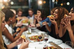 Ragazzi seduti a tavola che mangiano