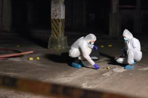 due membri della polizia scientifica a lavoro sulla scena del crimine