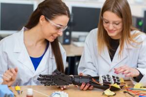 Donne scienziate che lavorano con camicie bianco
