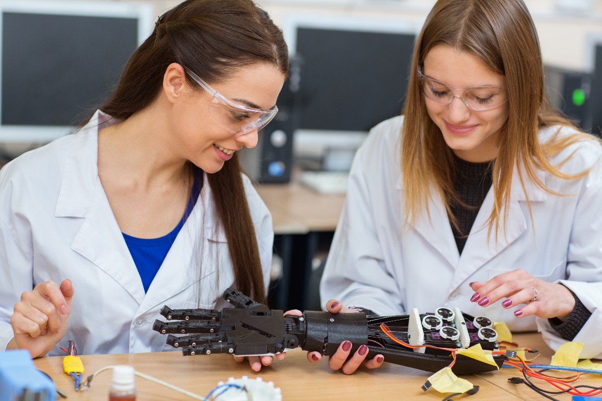 Donne scienziate che lavorano con camicie bianco