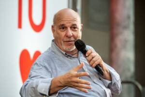 Alan Friedman ad un evento con un microfono in mano