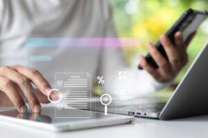 Gestione digitale: professionista al lavoro con smartphone e PC, rappresentazione della fatturazione elettronica.