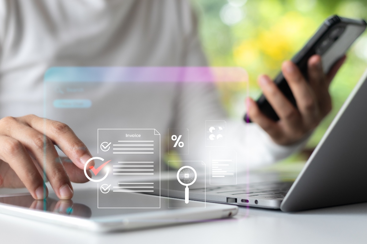 Gestione digitale: professionista al lavoro con smartphone e PC, rappresentazione della fatturazione elettronica.