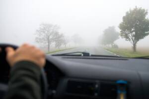 un'auto guida nella nebbia