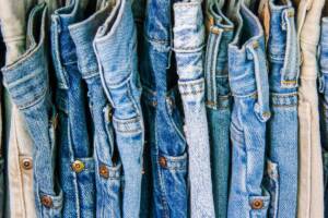 Varietà di denim: jeans di diverse tonalità appesi l'uno accanto all'altro.