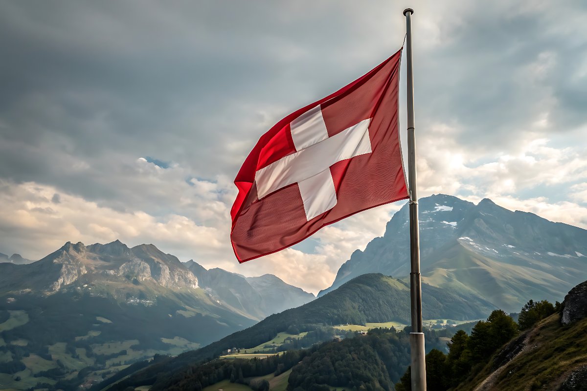 Bandiera svizzera che sventola davanti al maestoso panorama delle Alpi.