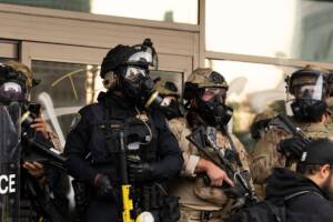 polizia ICE con maschere antigas