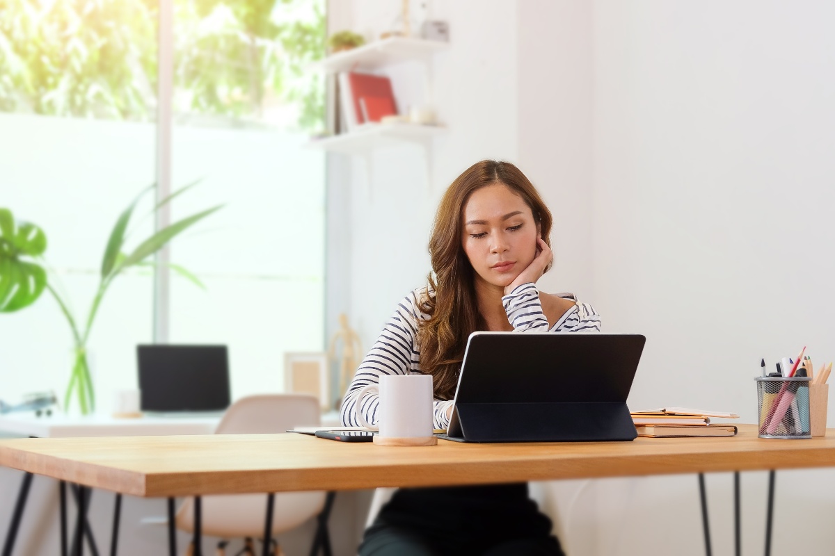 Una ragazza impegnata in smart working mentre lavora alla sua scrivania di casa.